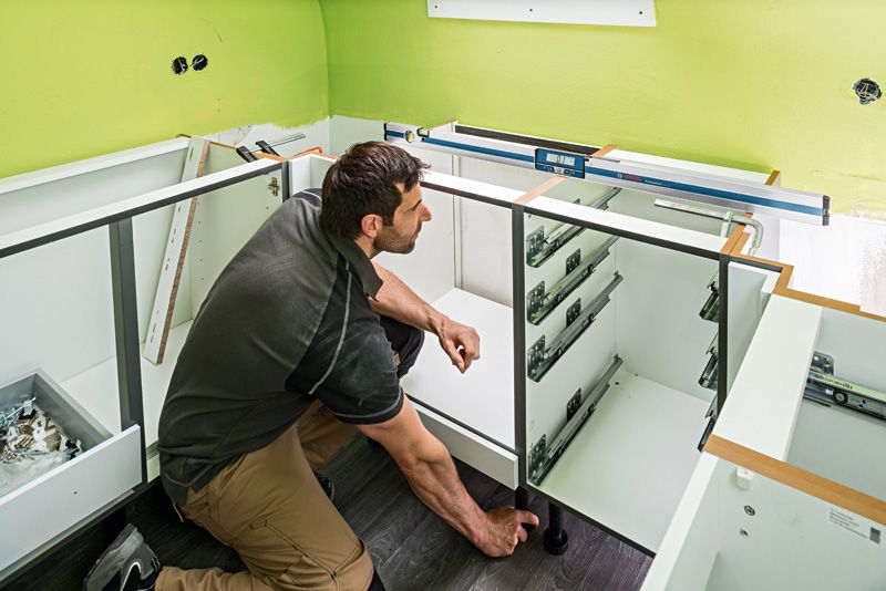 GIM 120 A person installs cabinetry while using a digital inclinometer on the counter.