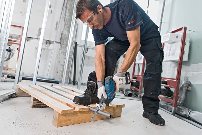 GSA 18V-LI C A person wearing safety equipment uses a reciprocating saw to cut a metal pipe.