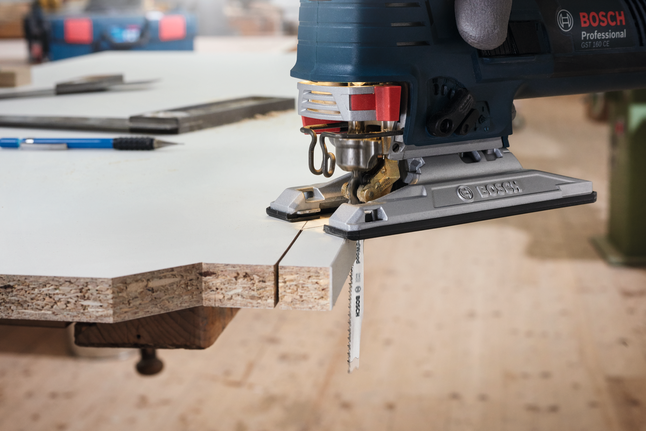 Jigsaw blade T 101 D Gloved worker uses a jigsaw to cut a precise line through laminated wood.