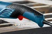 Close-up of a textured ergonomic power tool handle with a visible trigger.