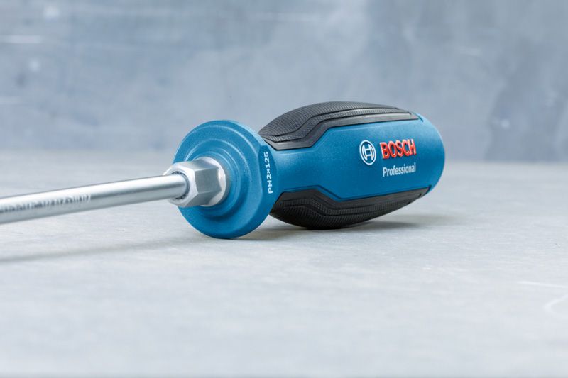 Screwdriver PH2X125 Blue and black screwdriver with ergonomic handle resting on a gray surface.