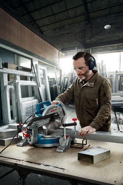 Man cutting metal with saw.