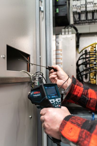 GIS 1000 C A person inspects an electrical panel with a handheld inspection camera.