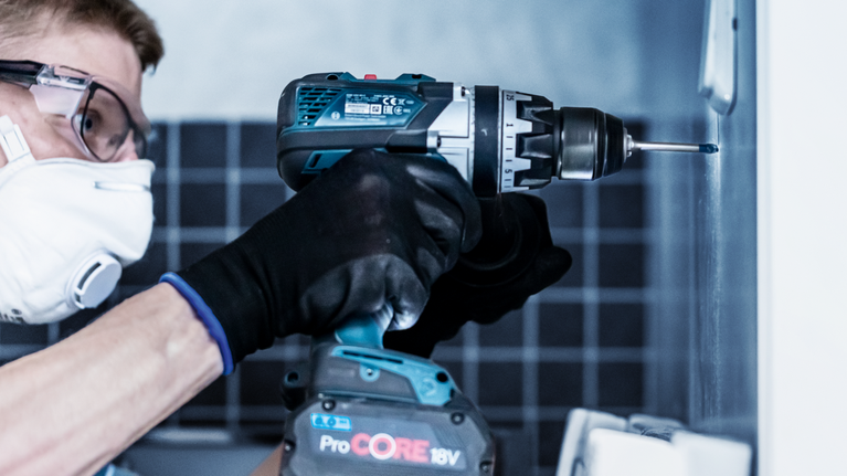 EXPERT Hard Ceramic HEX-9 Drill Bit Set, 5 x 90; 6 x 90; 8 x 90 mm, 3 pcs Person wearing safety equipment uses a cordless drill to drive a screw into a wall.