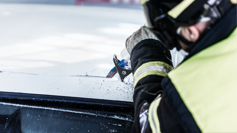 EXPERT ‘Vehicle Rescue’ S 957 CHM Reciprocating Saw Blade 1-pc Person wearing safety equipment cuts vehicle windshield with a power tool.
