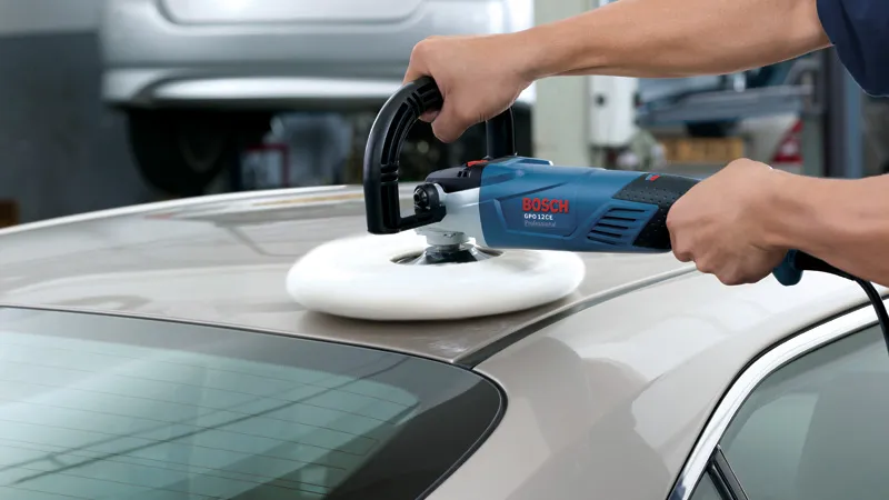 GPO 12 CE A person polishes a car roof with an electric polisher in a workshop.
