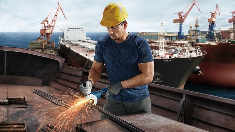 GWS 9-100 P Worker grinding metal, shipyard.