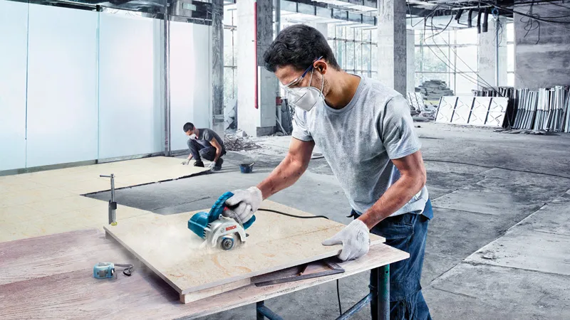 Bosch GDC 140 diamond tile cutter in use on a worksite.