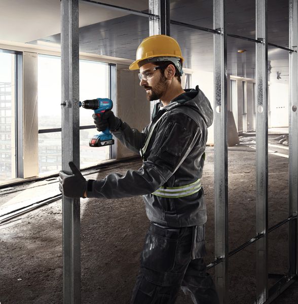 GSR 185-LI A person wearing safety equipment secures metal studs with a cordless drill.