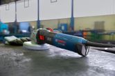 Angle grinder resting on a workbench in an industrial workshop.