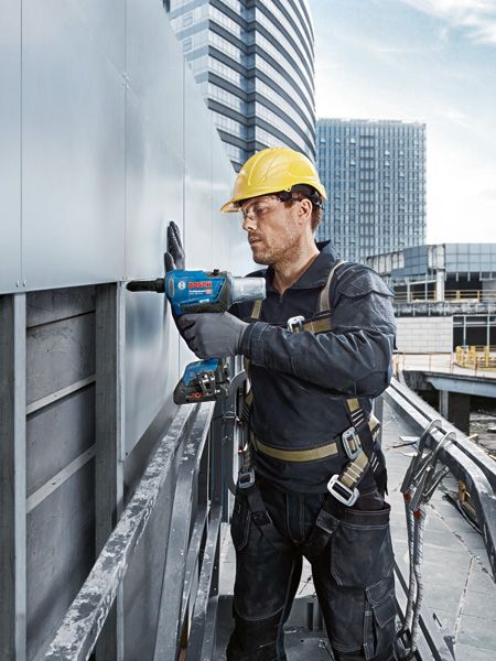 GRG 18V-16 C A person wearing safety equipment fastens metal siding using a cordless rivet gun.