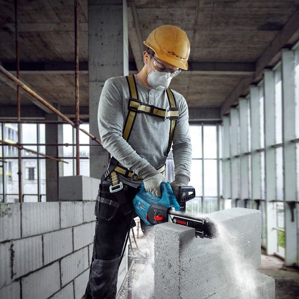 GAC 250 A person wearing safety equipment cuts an AAC block with a power cutter.