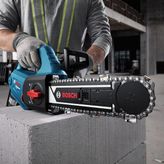 A person wearing safety equipment cuts a concrete block with an AAC block cutter.
