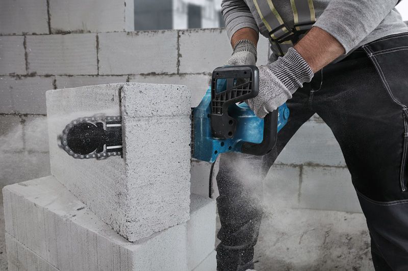 GAC 250 A person wearing safety equipment cuts an AAC block using a power cutter.