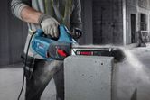 A person wearing safety equipment cuts an AAC block using an electric block cutter.