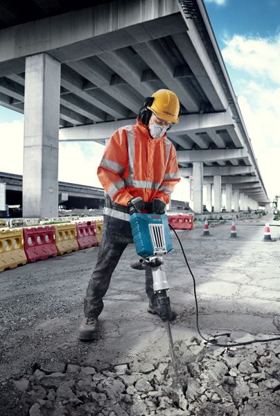 GSH 14 C A person wearing safety equipment breaks concrete with a large electric breaker outdoors.