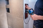 Person uses an inspection camera to examine inside a wall panel.