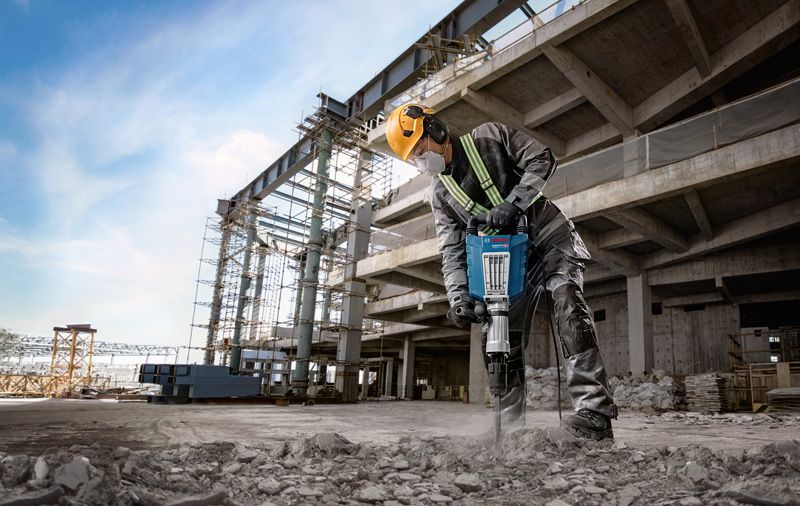 Worker using jackhammer onsite.
