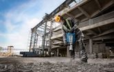 Worker using jackhammer onsite.