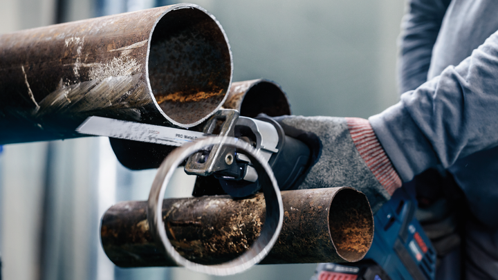 Object #200456606: 3046762_app_web_5 Person wearing safety equipment cuts a metal pipe with a reciprocating saw.