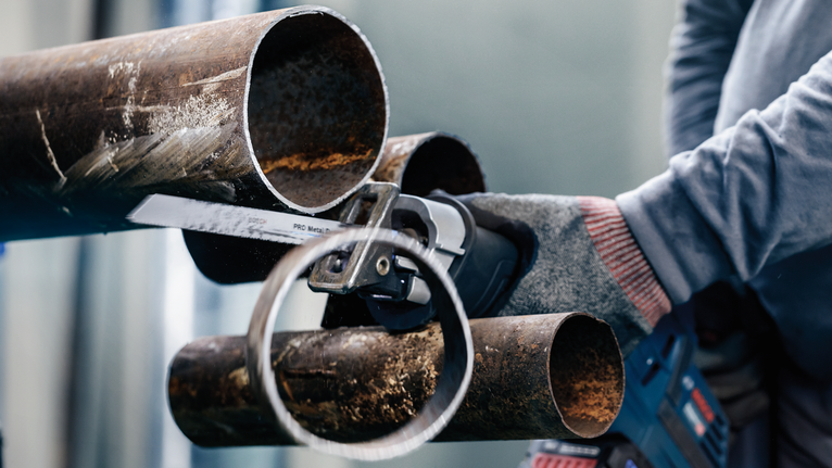 PRO Metal Demolition S1125VF Blade, 1.25 x 19 x 225 mm, 5 pcs Person wearing safety equipment uses a power saw to cut a metal pipe.