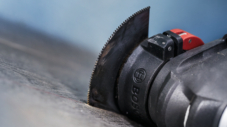 PRO ACZ 85 EIB Multitool Blade, 85 mm Oscillating multi-tool with a straight blade cutting into a dark surface.