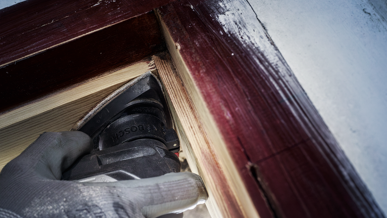 PRO AVZ 93 G Multitool Accessory, 93 mm Person wearing safety equipment sands wood near a painted window frame.