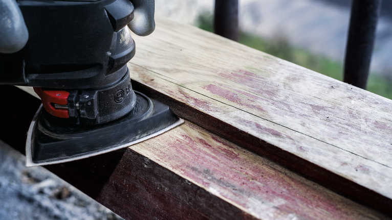 PRO AVZ 93 G Multitool Accessory, 93 mm Person wearing safety equipment sands a wooden plank with a power sander.
