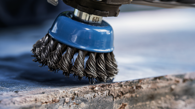 PRO Metal heavy Cup Brush, 75 x 0.5 mm, Thread Wire brush attachment cleaning rust from a metal surface.