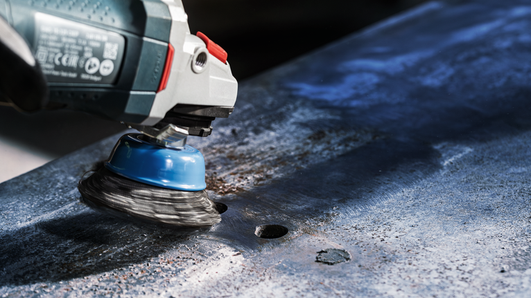 PRO Metal heavy Cup Brush, 75 x 0.5 mm, Thread Wire cup brush grinder removing rust from a metal sheet.