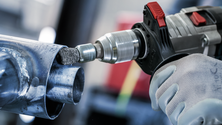 PRO Metal clean End Brush, Straight Shank, 25 x 0.3 mm Person wearing safety equipment uses a power drill to grind the inside of a metal pipe.