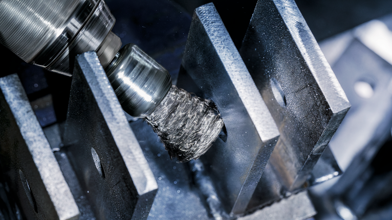 PRO Metal clean End Brush, Straight Shank, 25 x 0.3 mm A wire brush attachment polishes metal plates in an industrial setting.
