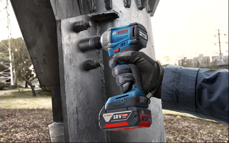 GDS 18V-350 A person wearing safety equipment uses a cordless impact wrench on a steel structure.