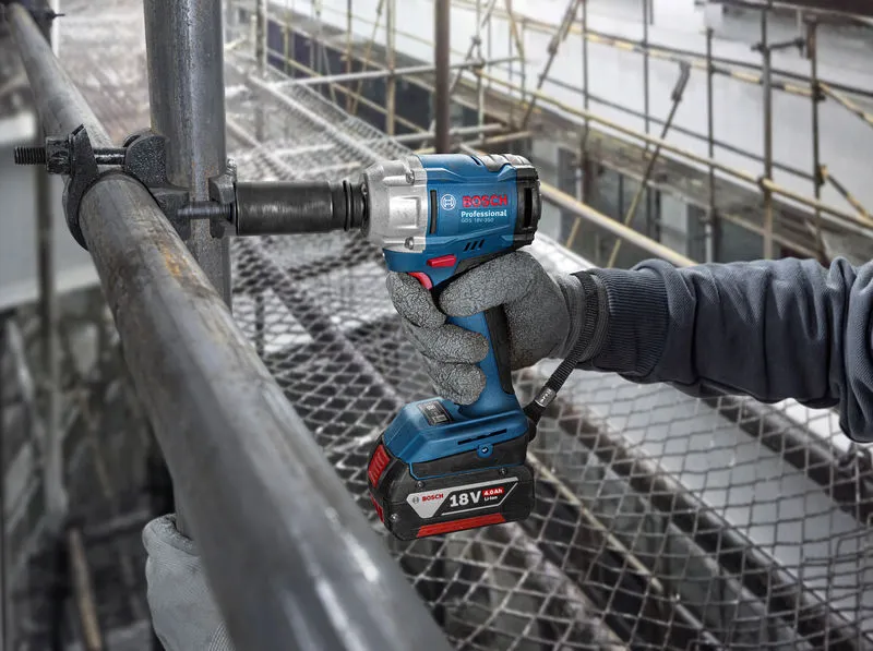 GDS 18V-350 + GSB 185 Combo A person wearing safety equipment uses a cordless impact wrench on scaffolding.