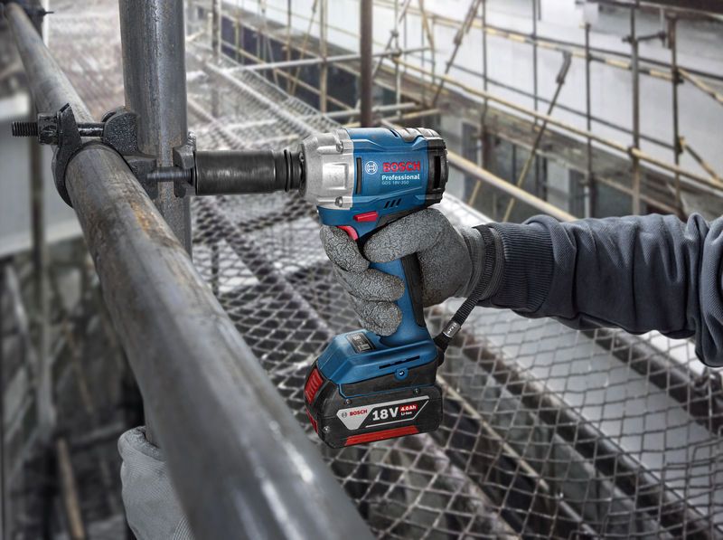 GDS 18V-350 A person wearing safety equipment uses a cordless impact wrench on scaffolding.