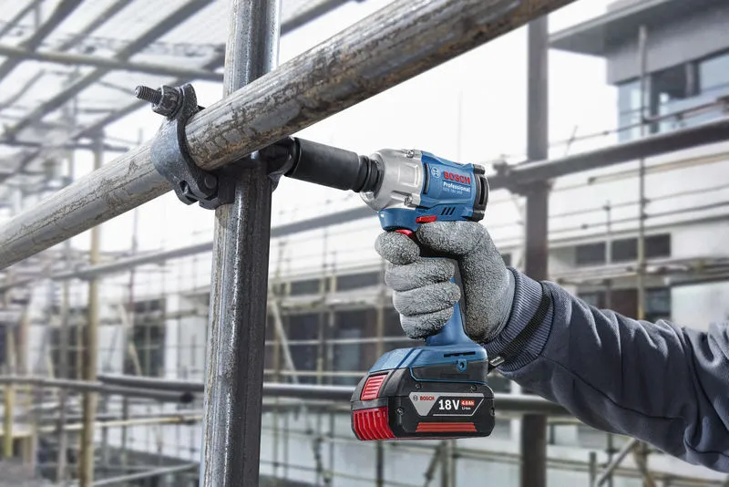 GDS 18V-350 + GSB 185 Combo A person wearing safety equipment uses a cordless impact wrench on scaffolding.