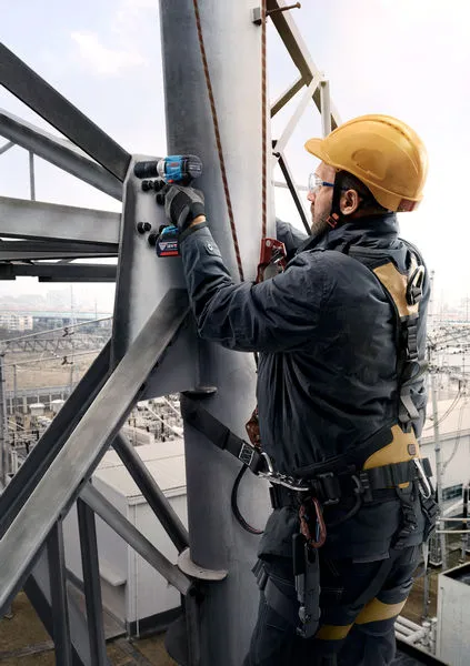 GDS 18V-350 + GSB 185 Combo A person wearing safety equipment uses a cordless drill on a metal structure.