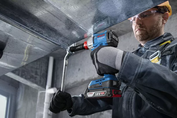 Professional Promotion Set of Combo GDX 18V-285 + GSB 185-LI with 2x2.0Ah, GAL 18V-20 in Case A person wearing safety equipment uses a cordless drill to fasten a metal duct.