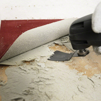 HCS scraper ATZ 52 SFC, flexible Person wearing safety equipment uses a power tool to remove adhesive under flooring.