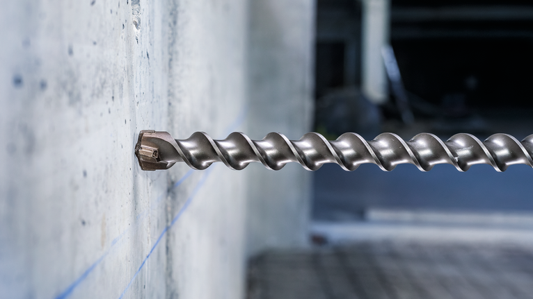 PRO SDS-max-7 Drill Bit, 35x400x520 mm Large masonry drill bit boring into a concrete wall.
