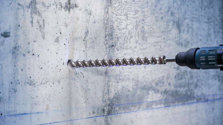 PRO SDS-max-7 Drill Bit, 35x400x520 mm Rotary hammer drilling a hole in a concrete wall.