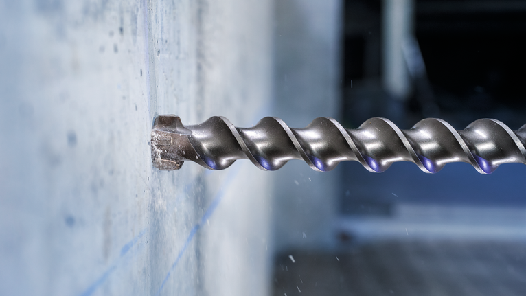 PRO SDS-max-7 Drill Bit, 35x400x520 mm Large drill bit boring into a concrete wall.