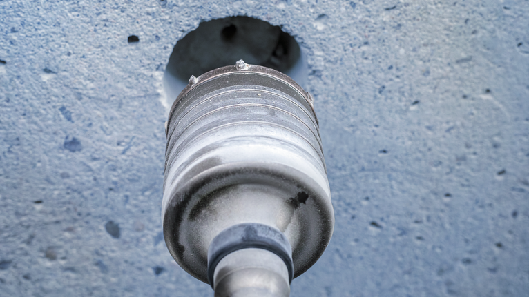 Core drill bit creating a circular hole in a concrete wall.