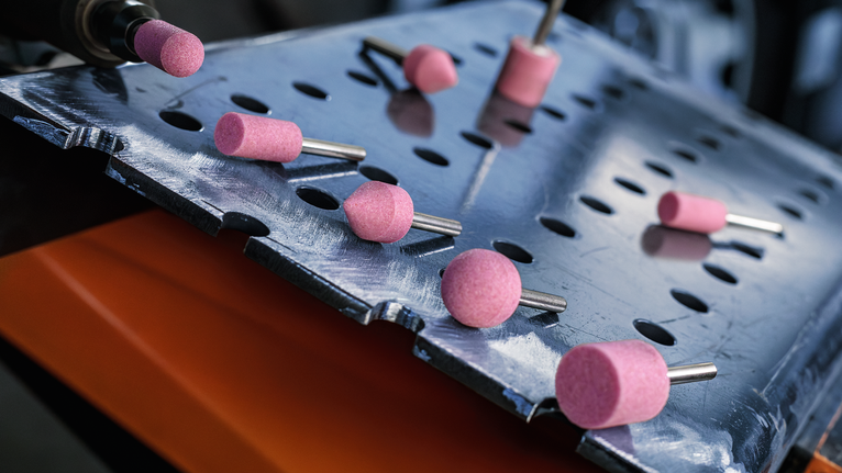 PRO Steel Mounted Point Set, 25 x 24; 15 x 30; 15 x 30; 25 x 25; 20 x 25 mm, G60; G60; G60; G60; G60, 5 pcs Rotary grinding bits placed on a perforated metal sheet.