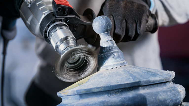 PRO Metal clean Cup Brush, Straight Shank, 70 x 0.3 mm Person wearing safety equipment uses a power drill with a hole saw on a painted metal structure.