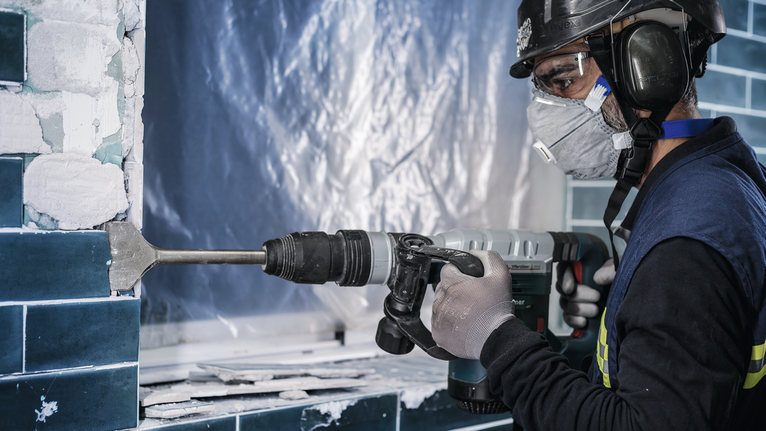 PRO SDS max-4C Tile Chisel, 80 x 300 mm A person wearing safety equipment removes wall tiles using a rotary hammer.
