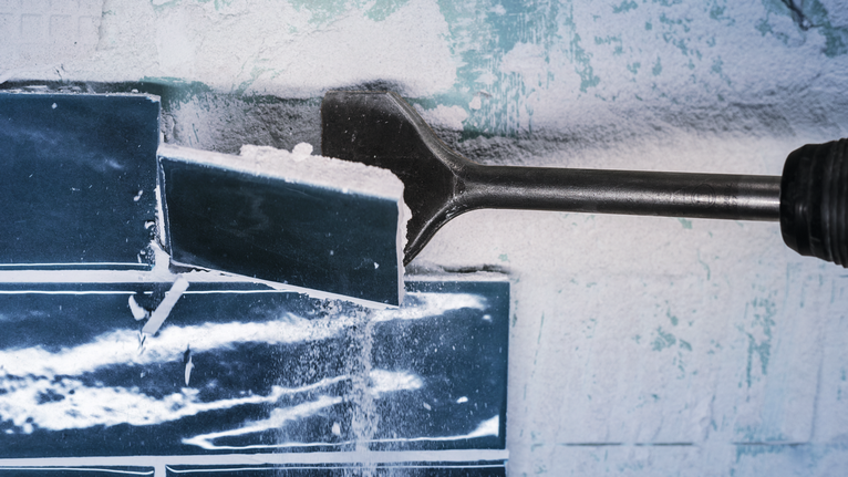 PRO SDS max-4C Tile Chisel, 80 x 300 mm Chisel attachment removes a ceramic tile from a wall.