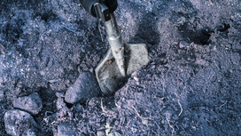 Chisel tool breaking compact soil and rocks.
