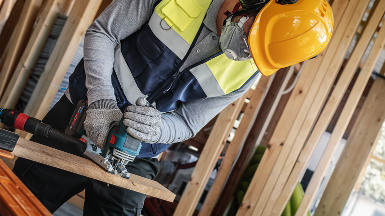 PRO Hardwood fast T144DF Jigsaw Blade, 100 mm, 5 pcs A person wearing safety equipment uses a jigsaw to cut a wooden board.