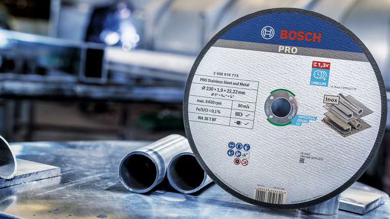 PRO Stainless Steel and Metal Bonded Cutting Disc, 230 x 1.9 x 22.23 mm, Straight Cutting disc displayed on a metal work surface near stainless steel pipes.